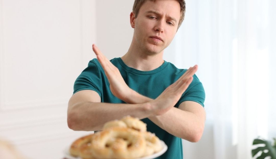Mladić odbija kolač koji mu majka pruža, simbolizujući kontrolu nad ishranom i emocionalnu povezanost sa hranom.