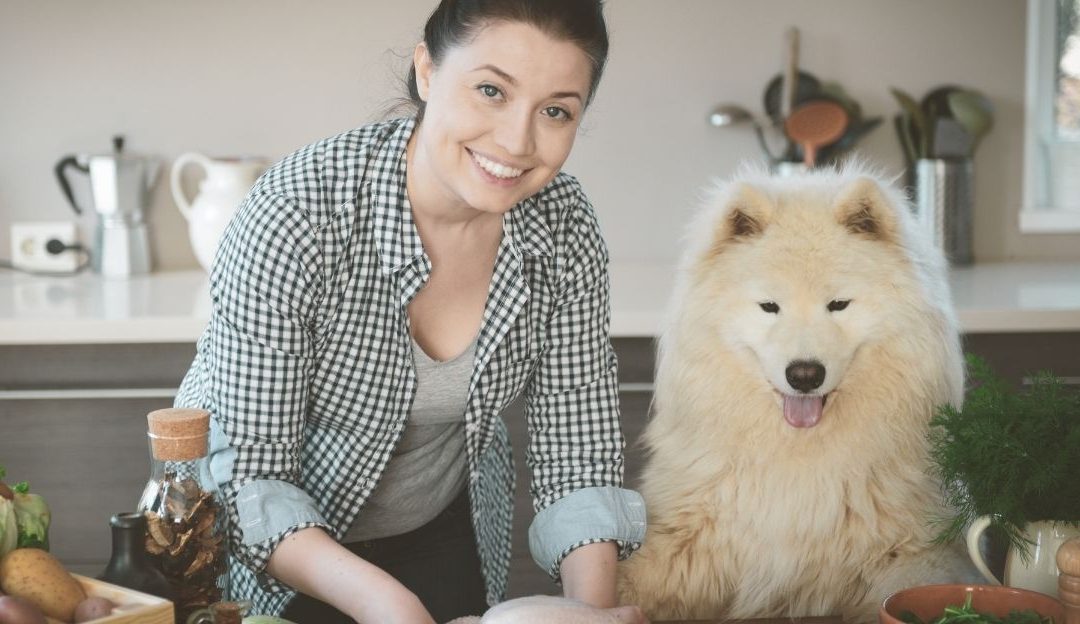 Vlasnik u kuhinji priprema obrok za svog psa