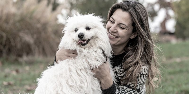 Autentična žena koja se ne stidi svojih bora u emotivnom trenutku sa psom.