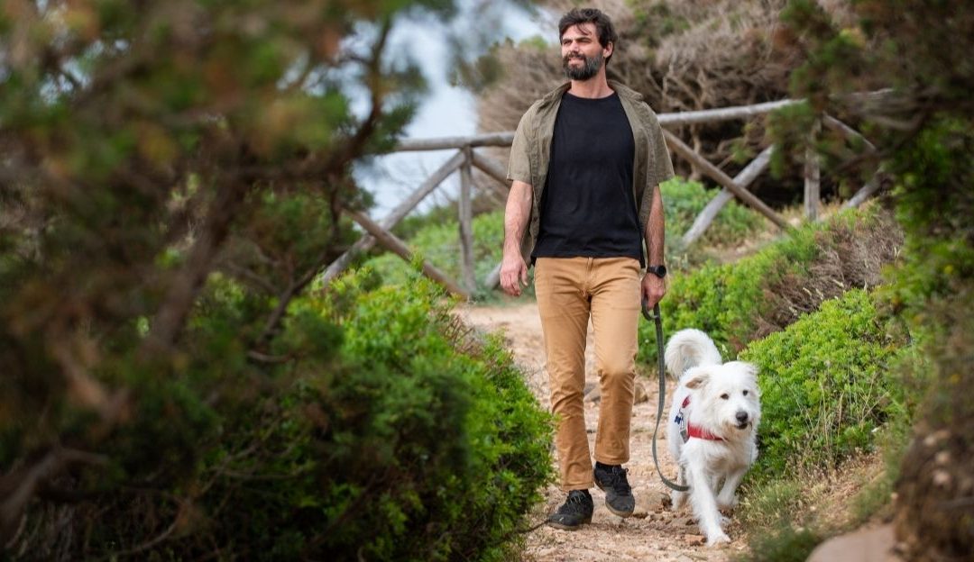 Vlasnik koji mirno i bez kontakta očima vodi psa, simbol liderstva.