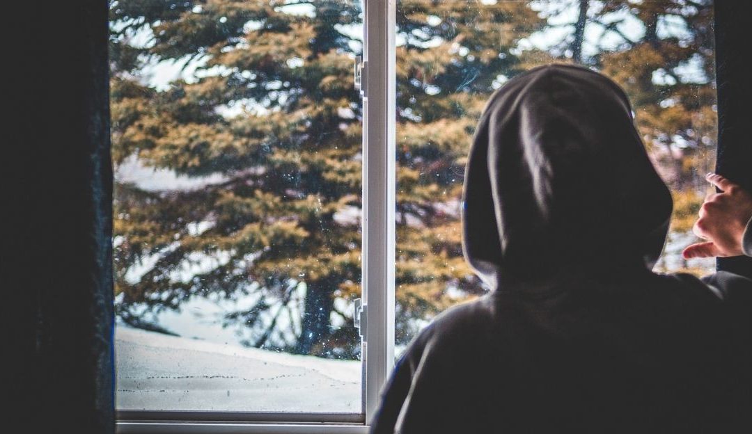 Osoba koja sedi sama, ilustrujući koncept usamljenosti koja nastaje usled stalnog osuđivanja drugih.